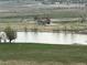 Captured lake view featuring an outbuilding, grassy lawn, and trees at 13456 Via Varra # 406, Broomfield, CO 80020