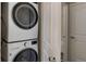 Stacked washer and dryer unit with a view into an adjacent bathroom at 13456 Via Varra # 406, Broomfield, CO 80020