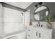 Bathroom featuring a tiled shower-tub, round mirror, marble countertop, and modern fixtures, creating a clean space at 1410 Vine St # 3, Denver, CO 80206