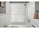 Bathroom with a white tiled shower-tub combination and a marble-topped vanity, creating a bright and functional space at 1410 Vine St # 3, Denver, CO 80206
