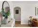Hallway featuring an arched doorway, a decorative mirror and table, and a glimpse into the home's interior at 1410 Vine St # 3, Denver, CO 80206