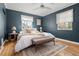 Bedroom with blue walls, white linens, decorative pillows, and natural light at 1410 Vine St # 3, Denver, CO 80206
