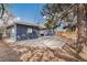 Spacious backyard with a concrete patio area, blue siding, and a partial view of the wooden fence at 2718 S Hazel Ct, Denver, CO 80236