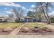 Charming blue home featuring well-kept landscaping, stone and a walkway to the front door at 2718 S Hazel Ct, Denver, CO 80236