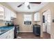 Compact kitchen features white cabinets, laminate counters, and access to the laundry at 2718 S Hazel Ct, Denver, CO 80236