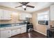 Kitchen features white cabinets, updated countertops, stainless steel range, and ceiling fan at 2718 S Hazel Ct, Denver, CO 80236