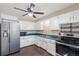 Functional kitchen featuring stainless steel appliances, white cabinetry, and good lighting at 2718 S Hazel Ct, Denver, CO 80236