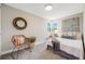 Charming bedroom with a rattan chair, window, and unique round mirror at 4507 W 2Nd Ave, Denver, CO 80219