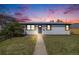Charming one-story home featuring a well-maintained lawn and a neatly landscaped front yard under a colorful dusk sky at 4507 W 2Nd Ave, Denver, CO 80219