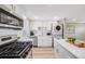 Modern, updated kitchen with white cabinetry, subway tile backsplash, stainless steel appliances, and in-unit laundry at 4507 W 2Nd Ave, Denver, CO 80219