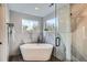 Stunning bathroom with a soaking tub, marble accents, a glass shower door, and natural light from surrounding windows at 11885 W Katherine Ave, Lakewood, CO 80401