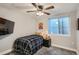 Cozy bedroom with a comfortable bed, a ceiling fan, and a view to the window at 11885 W Katherine Ave, Lakewood, CO 80401