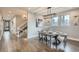 Bright dining room featuring wood floors, modern lighting, a large window, and seating for six at 11885 W Katherine Ave, Lakewood, CO 80401
