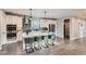Well-appointed kitchen with white cabinets, stainless steel appliances, large island with seating, and stylish pendant lighting at 11885 W Katherine Ave, Lakewood, CO 80401
