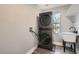 Functional laundry room with a stacked washer and dryer, along with a utility sink for added convenience at 11885 W Katherine Ave, Lakewood, CO 80401