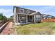 Expansive backyard featuring a covered patio, lush lawn, and wood fence at 15100 Gaylord St, Thornton, CO 80602