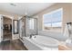 Bright bathroom with soaking tub, glass shower, and window provides a spa-like experience at 15100 Gaylord St, Thornton, CO 80602