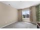 Bright bedroom features neutral walls, a window overlooking the neighborhood, and plush carpet at 15100 Gaylord St, Thornton, CO 80602