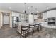 Open kitchen featuring a large island with seating, stainless steel appliances, and modern finishes at 15100 Gaylord St, Thornton, CO 80602