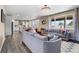Open-concept living room with hardwood floors, large windows, and a view of the kitchen at 15100 Gaylord St, Thornton, CO 80602