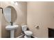 Neutral powder room with pedestal sink, round mirror, and toilet offers practical functionality at 15100 Gaylord St, Thornton, CO 80602