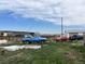 Spacious property featuring various vehicles, structures, and equipment, under an expansive sky at 15200 Holly St, Thornton, CO 80602