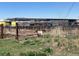 View of land showing a large building construction site and rusted metal fencing at 15200 Holly St, Thornton, CO 80602