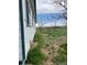 Side yard with thriving foliage along the house, adjacent to a grassy expanse with sparse trees at 15200 Holly St, Thornton, CO 80602