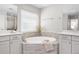 Bright bathroom featuring a soaking tub with gray tile surround, dual sinks and walk-in shower at 15608 E Otero Cir, Centennial, CO 80112