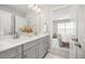 Double vanity bathroom featuring gray cabinetry, white countertops, and a view into the well-lit bedroom at 15608 E Otero Cir, Centennial, CO 80112