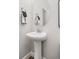Bathroom features a white pedestal sink with a modern mirror and grey walls, creating a clean and elegant look at 15608 E Otero Cir, Centennial, CO 80112