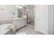 Bathroom featuring a glass shower and white cabinets, complementing the soaking tub in the background at 15608 E Otero Cir, Centennial, CO 80112