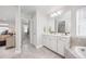 Light and airy bathroom with tile floors, white vanity and soaking tub, open to the bedroom at 15608 E Otero Cir, Centennial, CO 80112
