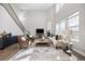 Bright living room with a fireplace, soaring ceilings, and large windows providing ample natural light and an open staircase at 15608 E Otero Cir, Centennial, CO 80112