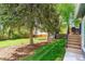 Spacious backyard with lush green grass, mature trees, and a charming swing set at 6537 S Brentwood Way, Littleton, CO 80123