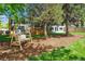 Large backyard featuring a wooden swing, lush green grass, and mature trees at 6537 S Brentwood Way, Littleton, CO 80123