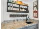 Attractive home bar setup featuring granite counters, gray cabinetry and a well-stocked beverage shelf at 6537 S Brentwood Way, Littleton, CO 80123