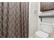 Cozy bathroom showcasing a patterned shower curtain, convenient toilet, and storage at 6537 S Brentwood Way, Littleton, CO 80123