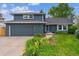 Charming home featuring a well-manicured lawn and a gray two-car garage for ample parking and storage space at 6537 S Brentwood Way, Littleton, CO 80123