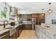 Modern kitchen featuring stone countertops, a farmhouse sink, and stainless-steel appliances with lots of cabinets at 6537 S Brentwood Way, Littleton, CO 80123