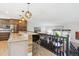 Open kitchen with granite counters, stainless appliances, pendant lighting, and breakfast bar seating at 6537 S Brentwood Way, Littleton, CO 80123