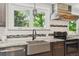 Well-lit kitchen featuring stainless steel appliances, granite countertops and a farmhouse sink for modern functionality at 6537 S Brentwood Way, Littleton, CO 80123