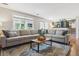 Spacious living room with expansive sectional sofa, windows, and view of the kitchen at 6537 S Brentwood Way, Littleton, CO 80123