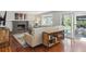 Cozy living room featuring a gray painted brick fireplace, hardwood floors, and large sliding glass doors at 6537 S Brentwood Way, Littleton, CO 80123