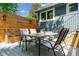 Outdoor patio area with a table, seating, wooden backdrop, and stylish lighting fixtures at 6537 S Brentwood Way, Littleton, CO 80123