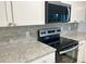 This is a close-up of the modern kitchen featuring gray subway tile backsplash and sleek stainless steel appliances at 912 S Dearborn Way # 3, Aurora, CO 80012