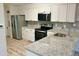 Renovated kitchen with stainless appliances, granite countertops, and white cabinets, laundry closet for added convenience at 912 S Dearborn Way # 3, Aurora, CO 80012