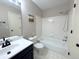 Clean bathroom featuring a vanity, toilet, and shower/tub combo with white tile surround at 16840 Hoot Owl Ct, Parker, CO 80134