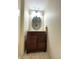 Bathroom featuring a round mirror, dark wood vanity with white countertop, and tiled floor at 16840 Hoot Owl Ct, Parker, CO 80134