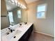 Bathroom featuring double sinks with black fixtures and a large mirror at 16840 Hoot Owl Ct, Parker, CO 80134